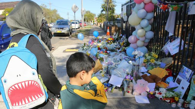 Rashani Uddin and son Zaryab lay flowers outside the school.