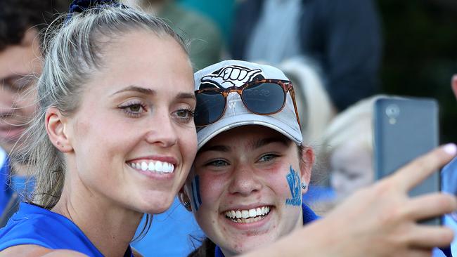 Kangaroos forward Kaitlyn Ashmore takes a selfie with a fan. Ashmore was one of North Melbourne’s best against the Crows, booting four goals. Picture: Kelly Defina/AFL Photos/ via Getty Images