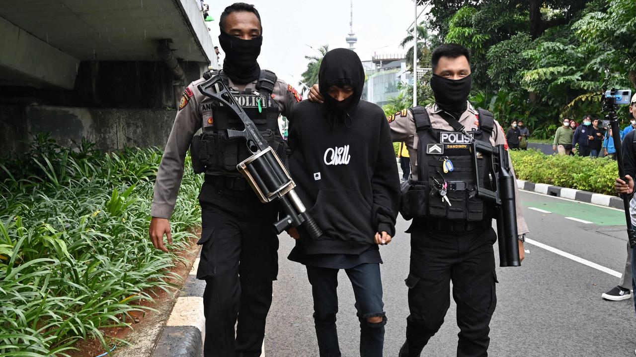 Police arrest a man during a rally against high prices of supplies in Jakarta. Picture: ADEK BERRY / AFP)