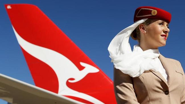 An Emirates flight attendant in front of a Qantas jet. The airlines’ partnership will continue for five more years.