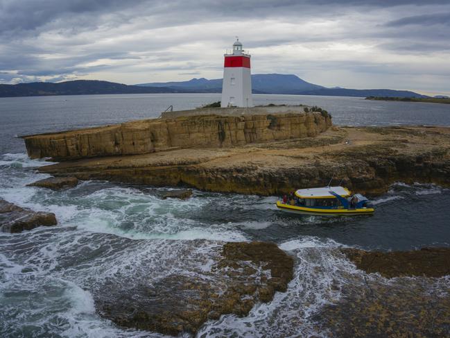 AUSTRALIA’S OLDEST: A Pennicott Wilderness cruise boat circles the Iron Pot Lighthouse.