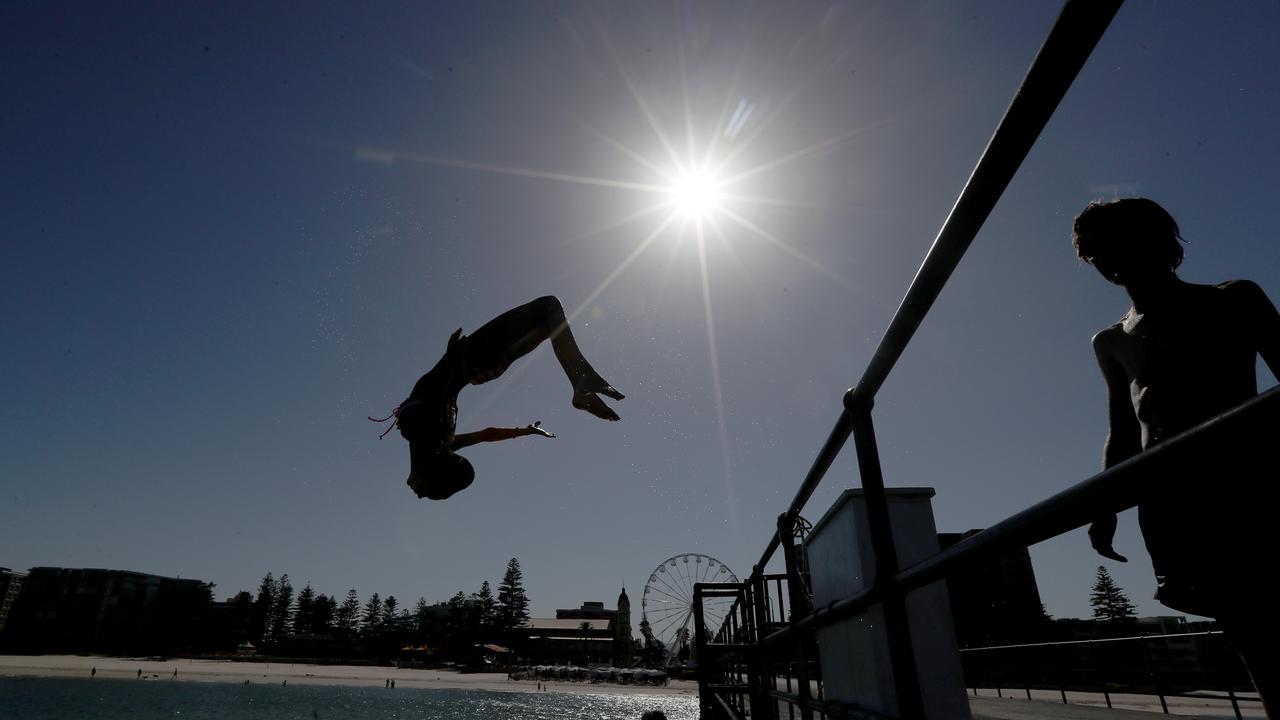 Jumping off the Glenelg Beach jetty. Picture: AAP Image/Kelly Barnes 