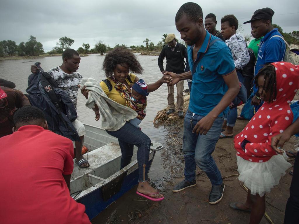 Locals helping each other to safety. Picture: Josh Estey/CARE