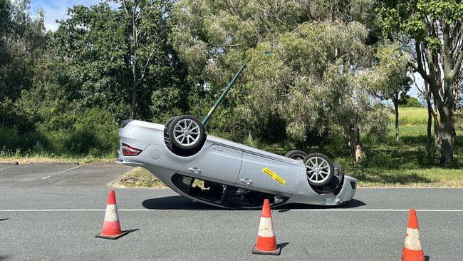 A car is on it's top after colliding with a light pole on a South Mackay street. Photo: Luke Lay