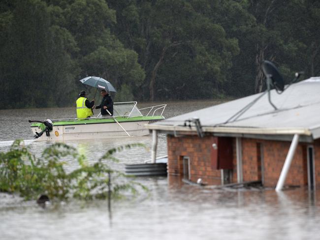 SYDNEY, AUSTRALIA - NewsWire Photos MARCH 22, 2021.Residents row past a home that has been completely covered by floodwaters in the suburb of Vineyard, near Windsor. Picture: NCA NewsWire / Jeremy Piper