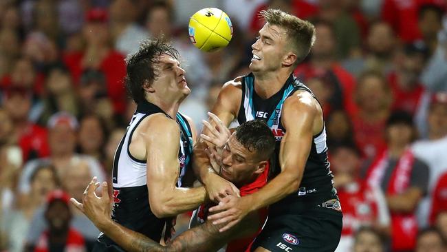 Swans star Lance Franklin is crunched in the contest by Power duo Jared Polec and Dougal Howard at the SCG on Sunday. Picture: Cameron Spencer/Getty Images