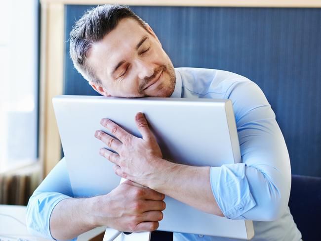 CAREERS FOR JUNE 13: Shot of a businessman hugging his monitor warmly.