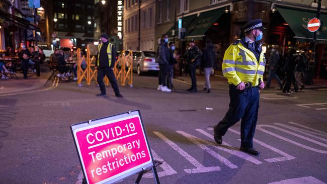 Police patrol in Soho, in central London as the clock nears 10pm, on the first day of 10pm closing times for pubs and bars. Picture: Tolga Akman/AFP