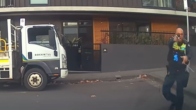 A police officer draws his weapon as the Mercedes allegedly speeds off.