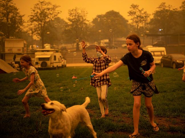 Children play at the showgrounds in the southern New South Wales town of Bega where they are camping after being evacuated from nearby sites affected by bushfires on December 31, 2019. - Thousands of holidaymakers and locals were forced to flee to beaches in fire-ravaged southeast Australia on December 31, as blazes ripped through popular tourist areas leaving no escape by land. Picture: Davey/AFP