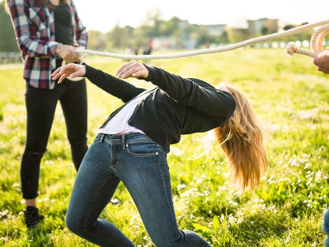 group of people playing limbo on the park