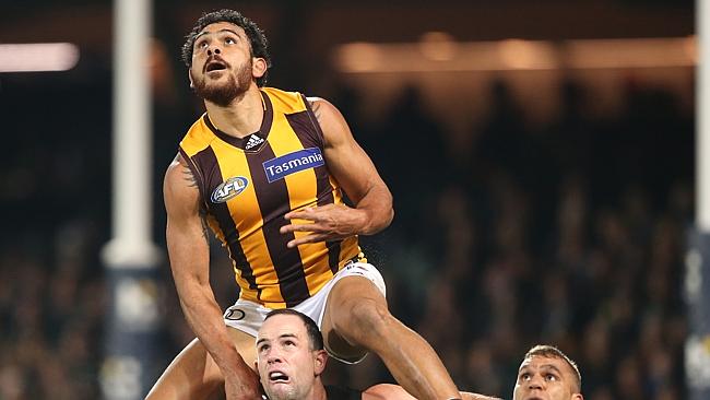 Cyril Rioli of the Hawks lines up a mark on top of Matthew Broadbent and Nathan Krakauer of the Power during the Round sixteen AFL match between Port Adelaide Power and the Hawthorn Hawks at Adelaide Oval in Adelaide, Thursday, July 7, 2016. (AAP Image/Ben Macmahon) NO ARCHIVING, EDITORIAL USE ONLY