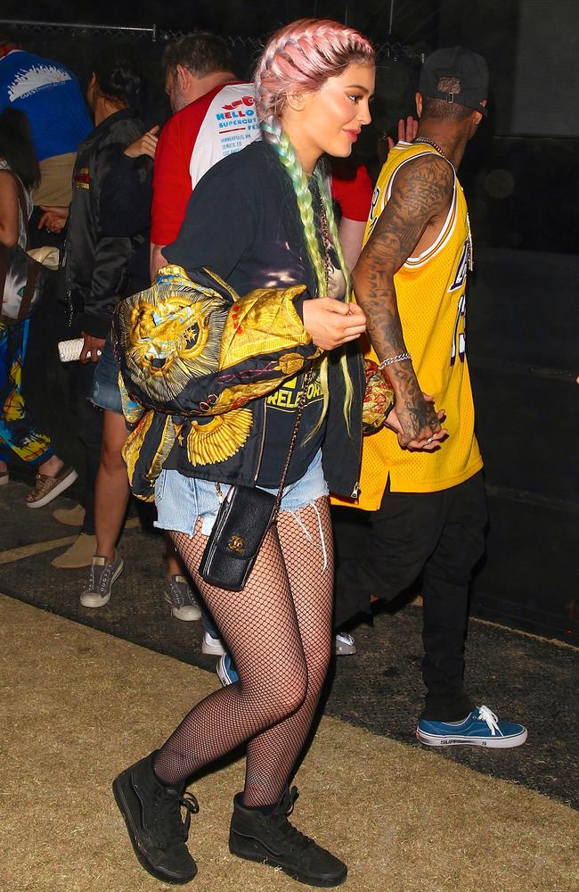 Fishnets, kicks, multi-coloured hair — how Kylie Jenner, pictured with boyfriend Tyga, did Coachella. Picture: BackGrid