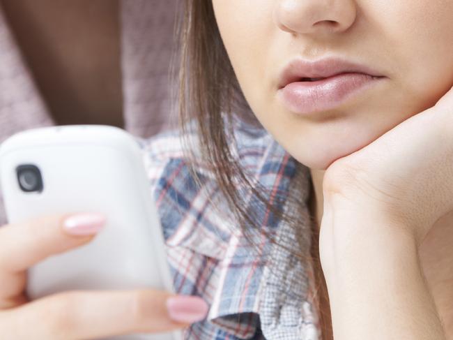 Mother Comforting Daughter Being Bullied By Text Message - Stock Image