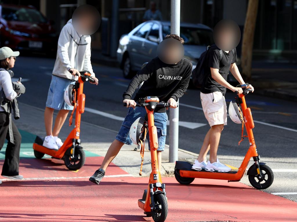 Young e-scooter riders in Brisbane not wearing helmets. Picture: David Clark