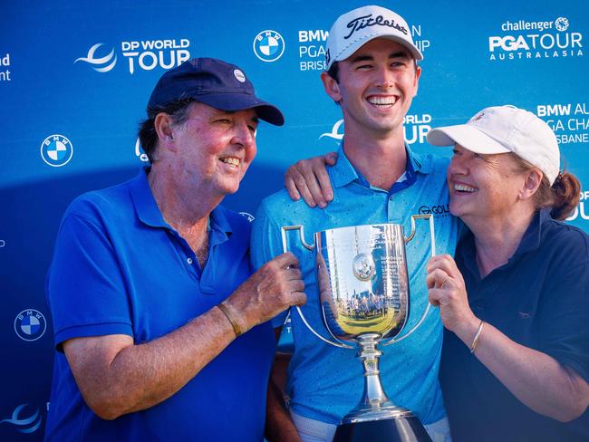 Elvis Smylie of Australia (C) holds the cup with his parents Peter (L) and Liz (R) after winning the Australian PGA Championship at Royal Queensland Golf Club in Brisbane on November 24, 2024. (Photo by Patrick HAMILTON / AFP) / -- IMAGE RESTRICTED TO EDITORIAL USE - STRICTLY NO COMMERCIAL USE --