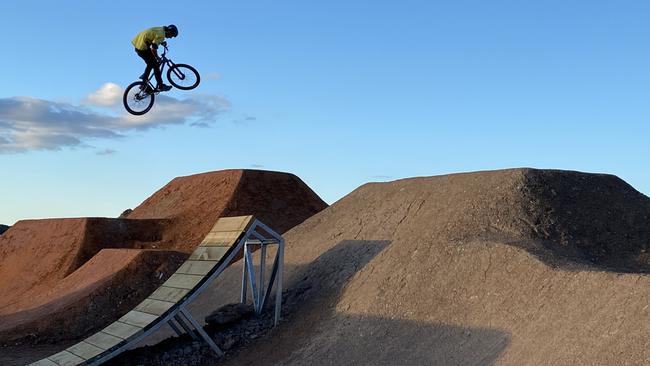 Jadon Wilson, 20, who has been working with Dirt Art on the new bike park track at Belrose. The wooden structure is one similar to that proposed at Manly Vale. Picture: Trail Care/Matthew Ward.