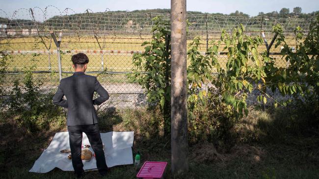 A North Korean refugee prepares to perform a ceremonial offering to relatives in North Korea, near the Demilitarised Zone (DMZ) during South Korea’s annual Chuseok harvest festival, a week-long holiday during which families typically offer thanks and prayers to their ancestors. Picture: AFP/Ed Jones