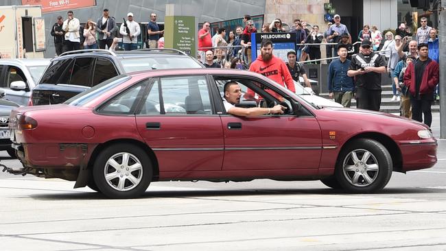 The driver does burnouts on the corners of Flinders and Swanston streets. Picture: Tony Gough