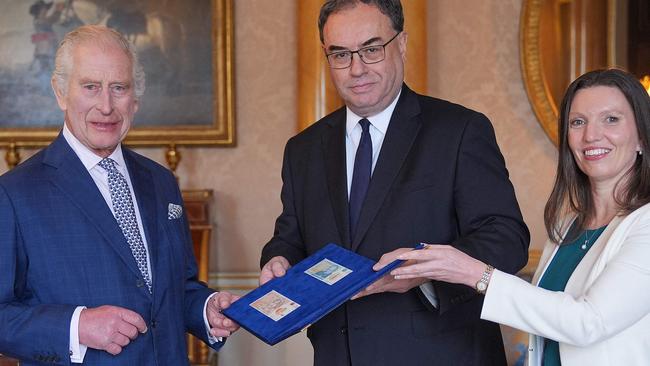 Britain's King Charles III (L) is reacts as Bank of England Governor Andrew Bailey (C) and Bank of England's Chief Cashier Sarah John present him with the first bank notes featuring his portrait, at Buckingham Palace in London on April 9, 2024. (Photo by Yui Mok / POOL / AFP)