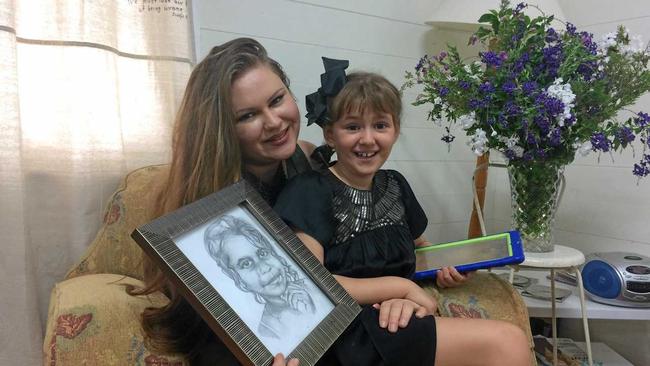 Dalveen artist Lyra Parker (left) with daughter Bella, 7, at the launch of Scenes of the Southern Downs art book, with one of Lyra's sketches. Picture: Elyse Wurm