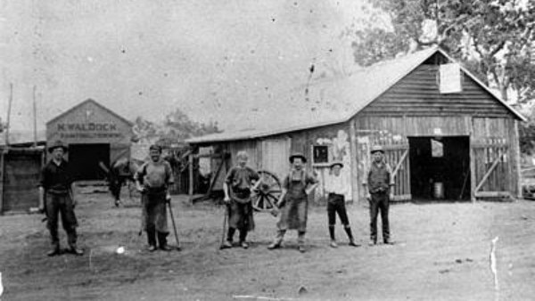 Blacksmiths pose in front of Waldock’s Blacksmith Shop in Murgon, ca. 1913. Wearing leather aprons and holding tools, the smithies showcase the trades that shaped the region’s early industry. Source: QldPics