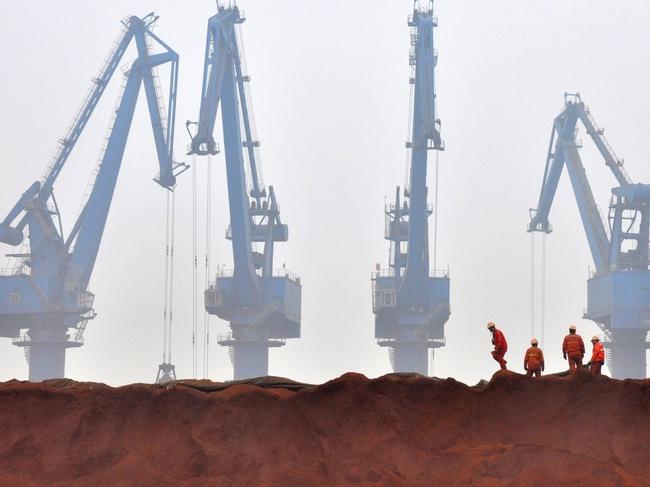 China’s steel sector is demanding ore imports with higher iron content, leading to pile-ups in port cities of lower-grade imports. Shown, workers prepare ore from Australia to be transported from a port in Tianjin. PHOTO: VINCENT DU/REUTERS