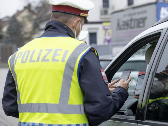 Austrian police officer check vaccination passports at a traffic stop. Picture: AFP