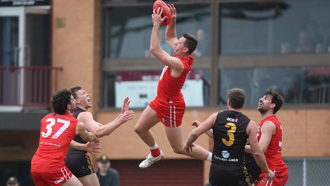 North Adelaide defender Cameron Craig jumps high to take a strong mark against Glenelg at Prospect Oval on Sunday. Picture: David Mariuz/SANFL