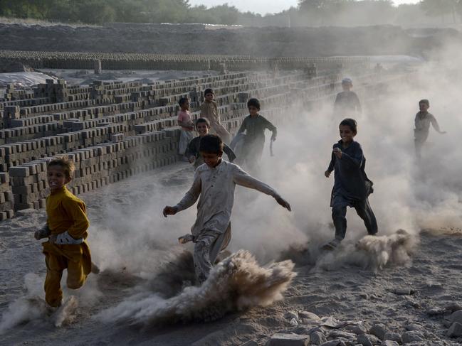 Afghan children run as they play along a dusty road on the outskirts of Jalalabad. Picture: AFP