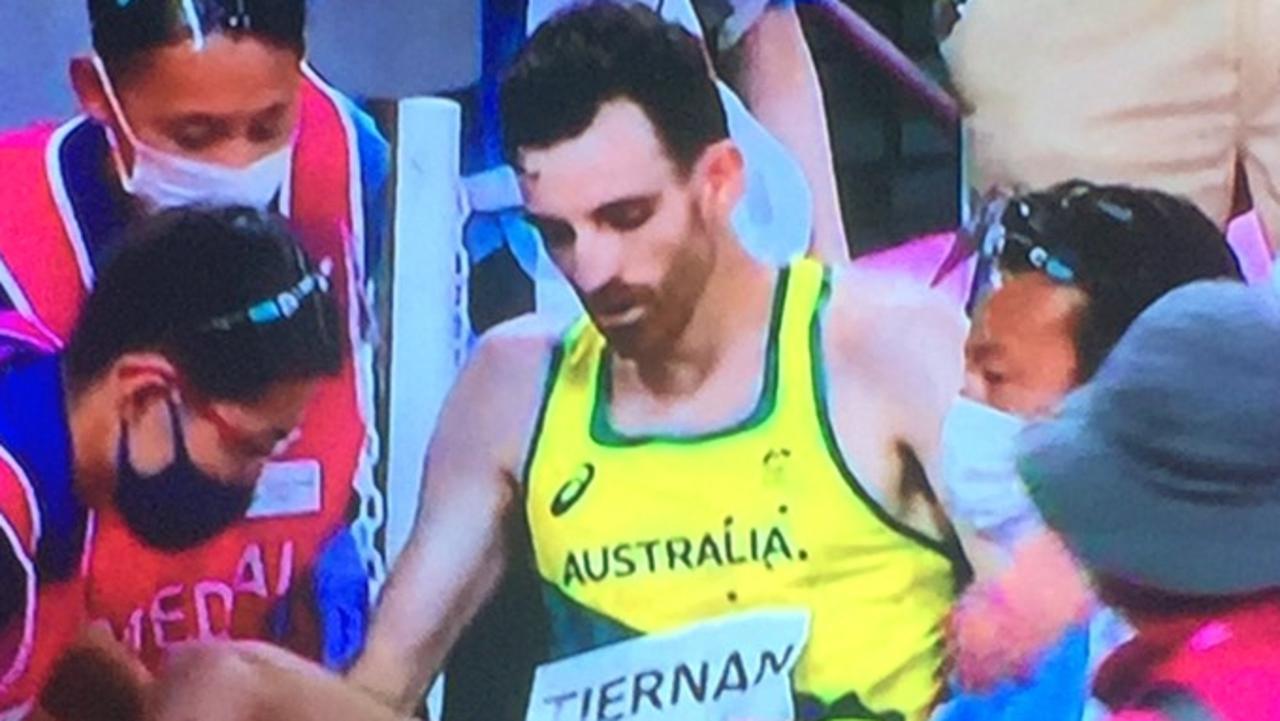 Patrick Tiernan is helped by officials into a wheelchair after he collapsed in the Men's 10,000m Final.