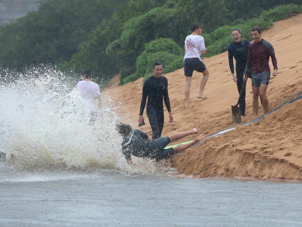 People sliding into Narrabeen Lagoon on Sunday. Picture: Damian Shaw