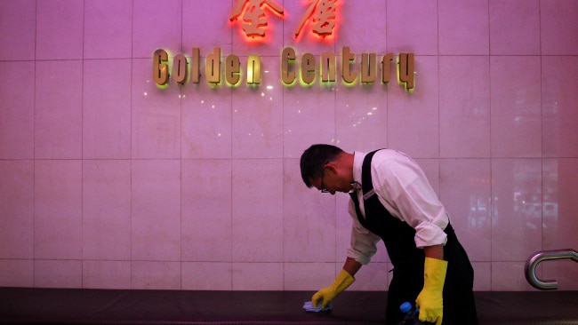 Restaurant waiter Ben cleans surfaces and hand railings at the award winning Golden Century Seafood Restaurant in Chinatown on March 5 2020. Picture: Getty Images