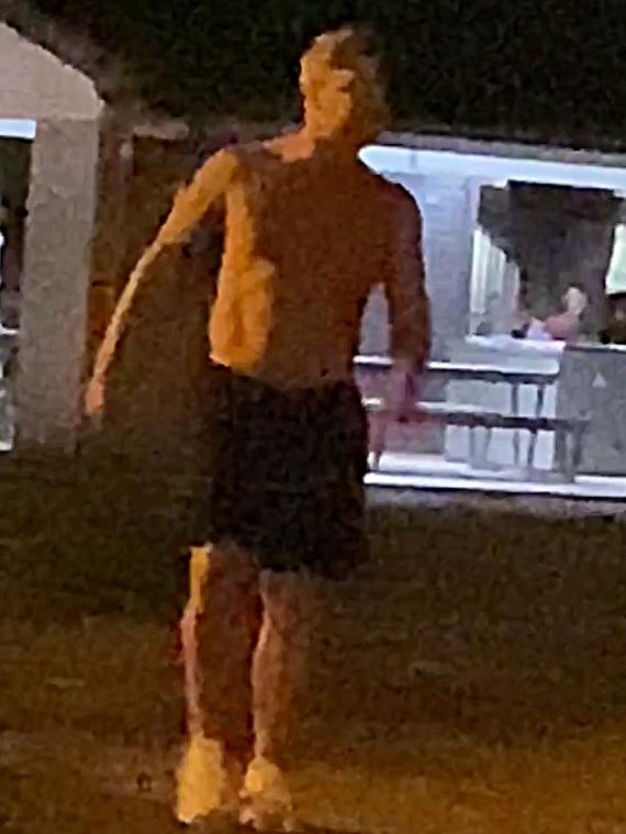 A limping Michael Clarke is seen, mid-barney, wearing shoes and shorts … but no shirt.