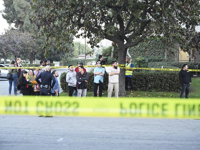 Workers stand near police lines at the scene of the plane crash. Picture: AP