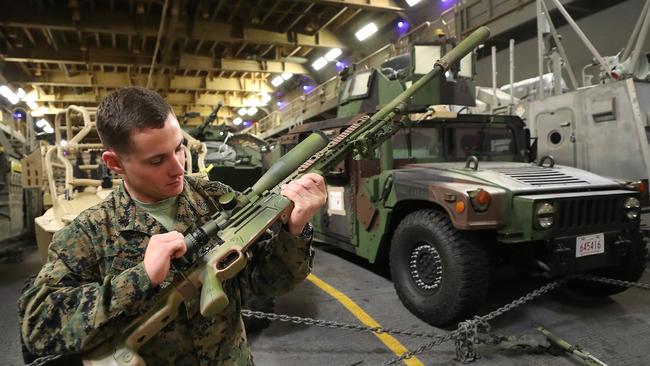 Scout sniper Sergeant Zechariah Knowlton inspecting his weapon. . Photos on board the USS Wasp.  Pic Peter Wallis