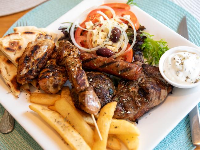 The classic mixed grill plate at Filoxenia includes a pork skewer kebab, lamb chop, a beef patty, Loukaniko pork sausage and chicken, with a pot of tzatziki on the side to soothe it all. Picture: Linda Higginson