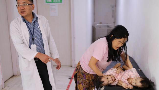 Paediatric surgeon Dr Karma Sherub and mum Bhumchu lay down Nima and Dawa, in the hospital ward for a checkup. Picture: Alex Coppel