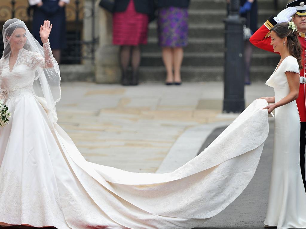 Catherine Middleton waves to the crowds as her sister and Maid of Honour Pippa Middleton holds her dress. Picture: Getty