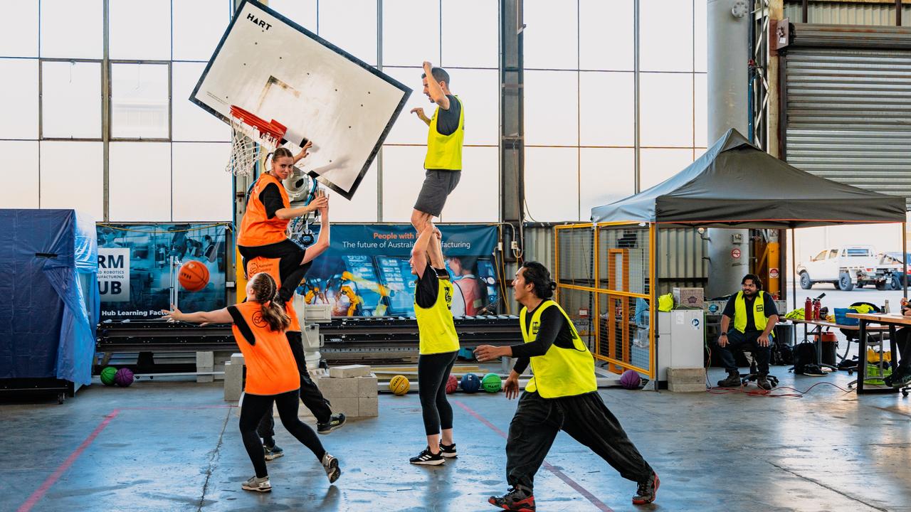 Students try to score against a moving basketball hoop controlled by a robotic arm at the Advanced Robotics for Manufacturing Hub.