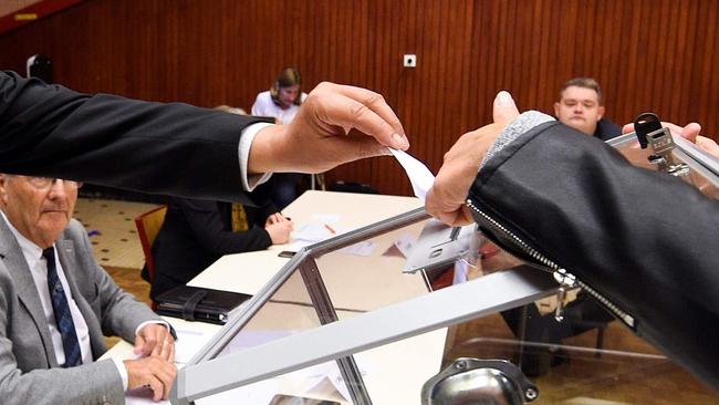 Candidate for the mayoral election Herve Feron (C), casts his vote in the ballot box during the election taking place during a municipal council, in Tomblaine, on May 23, 2020, as France eases lockdown measures taken to curb the spread of the COVID-19 (the novel coronavirus). - Herve Feron will be elected mayor Tomblaine (Photo by JEAN-CHRISTOPHE VERHAEGEN / AFP)