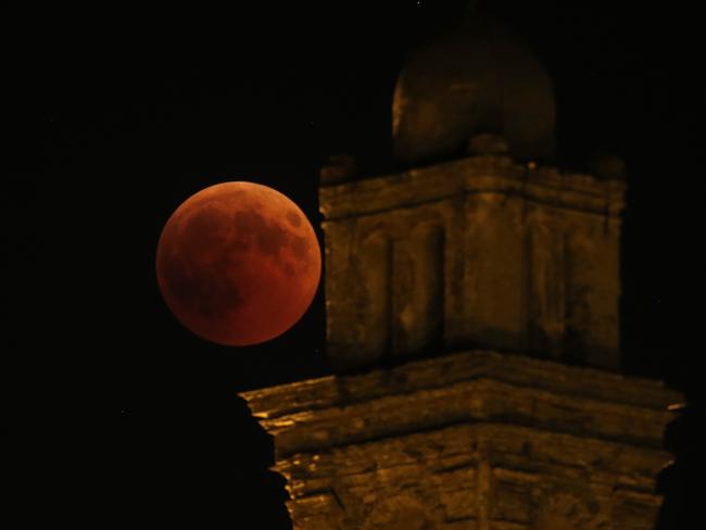 A "blood moon" eclipse beside the church of Venzolasca, on the French Mediterranean island of Corsica. Picture: AFP