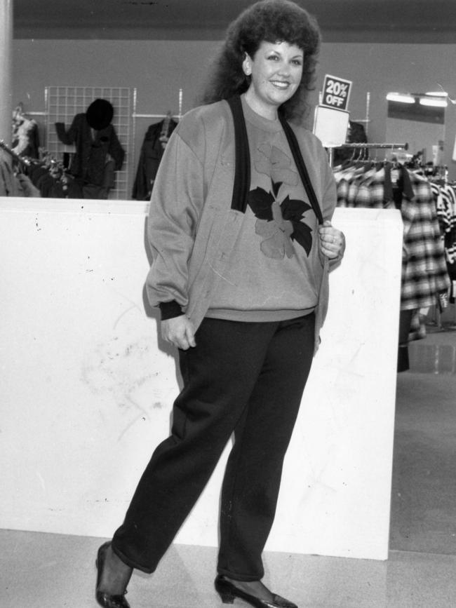 A model at Harris Scarfe wearing fleecy elastic-waisted pants, fleecy windcheater featuring a floral applique design, a fleecy button jacket and a frizzy perm in 1989.