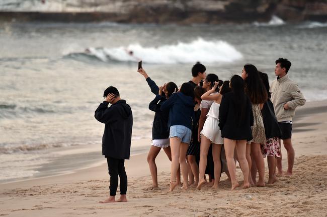 Revellers capturing a sunrise selfie on New Years Day at Bondi Beach in Sydney. Picture: AAP