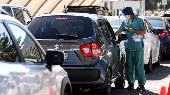 A worker deals with one of many people waiting for a PCR test at Bondi. Picture: Getty Images