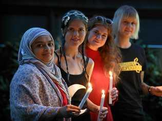 STAND AS ONE: Asraar Ismail, Rosie Williams, Lana Misick and Nina Ashfield-Crook hold a candle for the refugees on Manus and Nauru. Picture: Warren Lynam