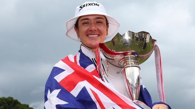 SINGAPORE, SINGAPORE - MARCH 03: Hannah Green of Australia poses with the trophy on the 18th green whilst wearing the Australian flag following victory on Day Four of the HSBC Women's World Championship at Sentosa Golf Club on March 03, 2024 in Singapore. (Photo by Andrew Redington/Getty Images)