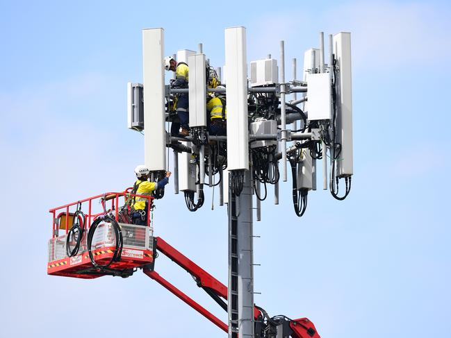 Telecommunications workers are seen working on a mobile cell tower at West Ryde, in Sydney.