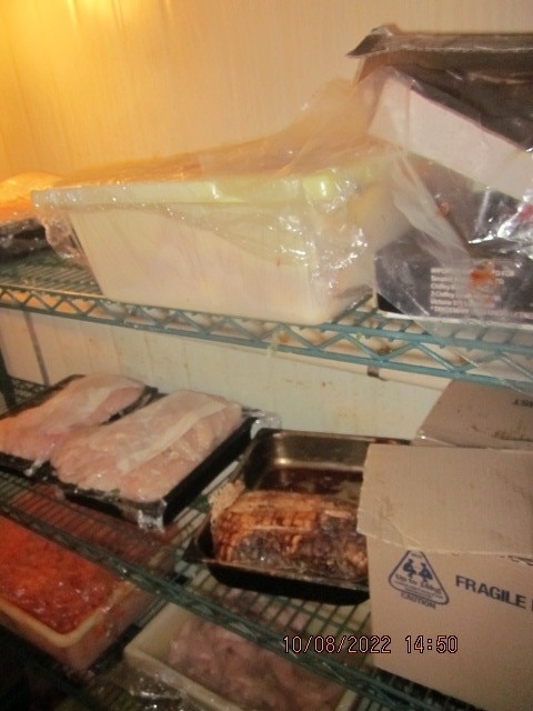 A photo of uncovered lamb seen under raw chicken and fish.