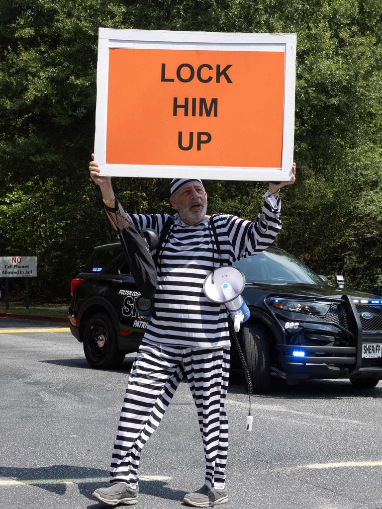 A protester holds a sign outside the Fulton County Jail. (Photo by Jessica McGowan / GETTY IMAGES NORTH AMERICA / Getty Images via AFP)